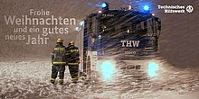 THW-Einsatzfahrzeug und THW-Helfer im Schneesturm